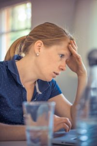 woman with hand on head feeling stressed