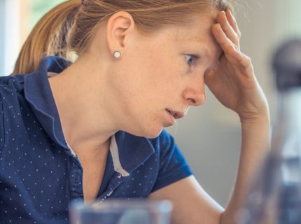 woman with hand on head feeling stressed