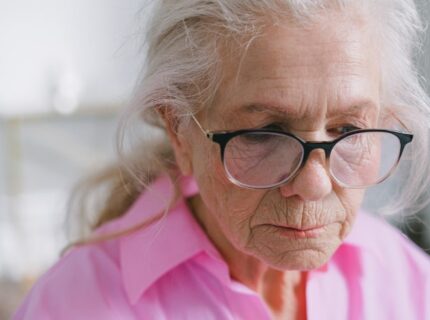 woman in pink shirt with glasses